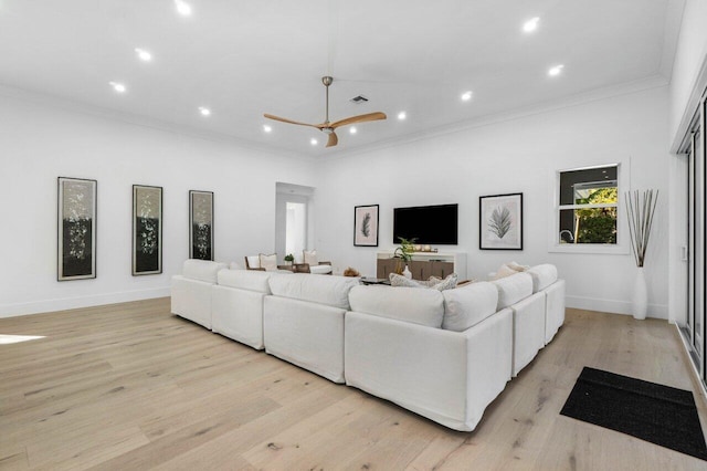 living room featuring ornamental molding, ceiling fan, and light wood-type flooring