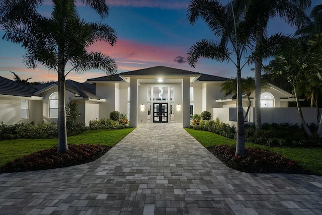 view of front of house featuring a yard and french doors