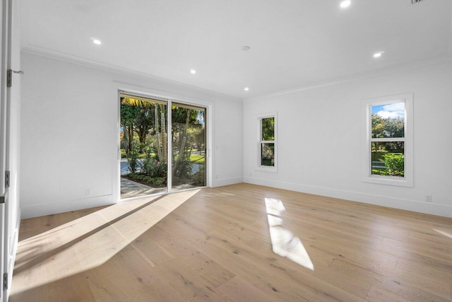 unfurnished room featuring crown molding, a wealth of natural light, and light wood-type flooring