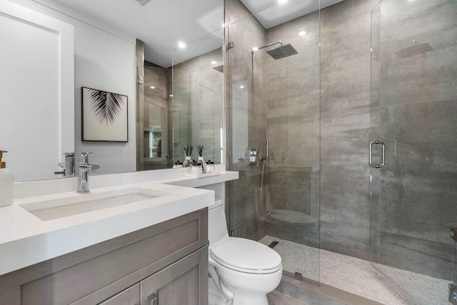 bathroom with vanity, an enclosed shower, and toilet