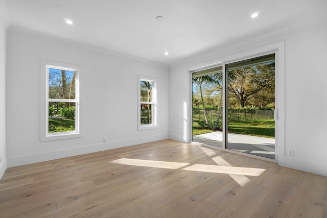 empty room with ornamental molding and light wood-type flooring