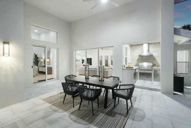 dining space with a towering ceiling and ceiling fan