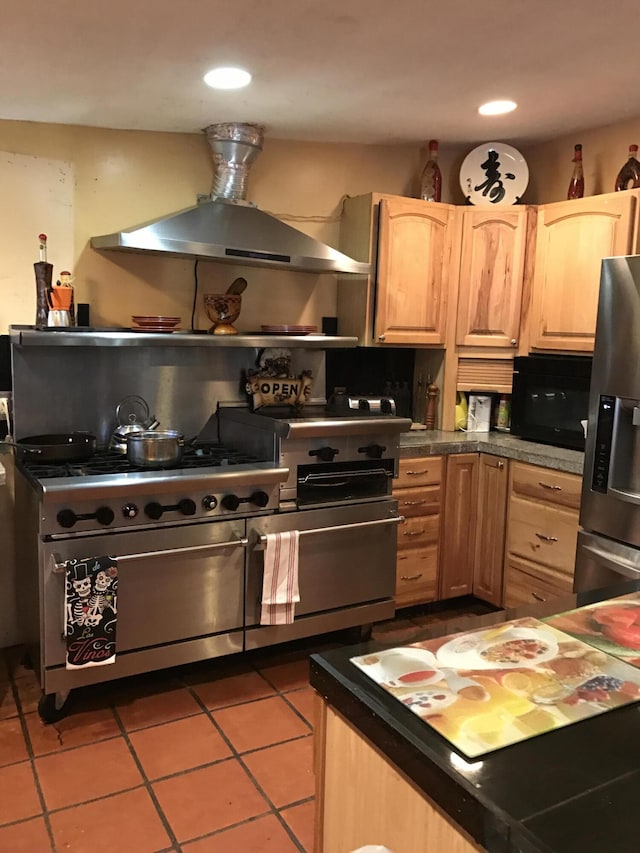 kitchen featuring light brown cabinetry, exhaust hood, decorative backsplash, appliances with stainless steel finishes, and light tile patterned flooring