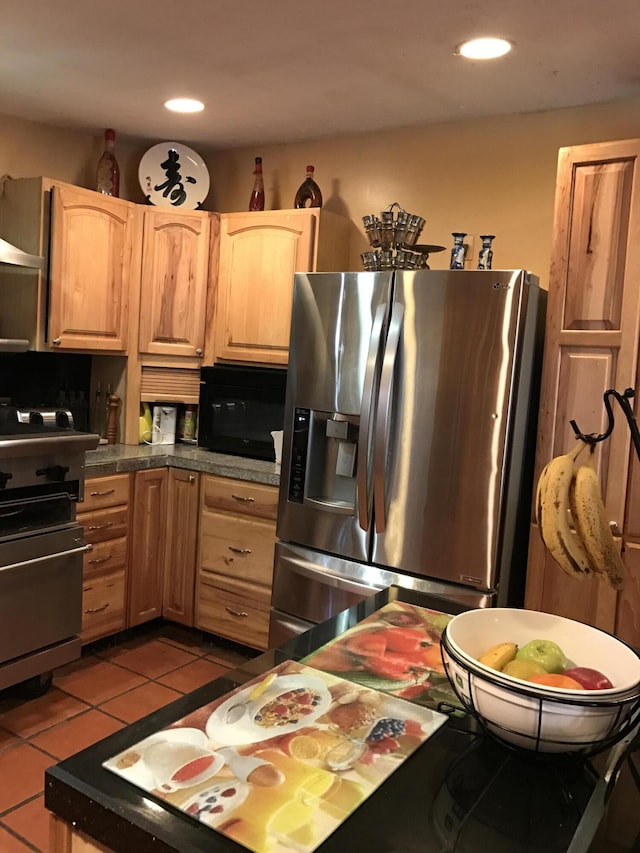 kitchen with light tile patterned flooring, stainless steel fridge, stove, and light brown cabinets