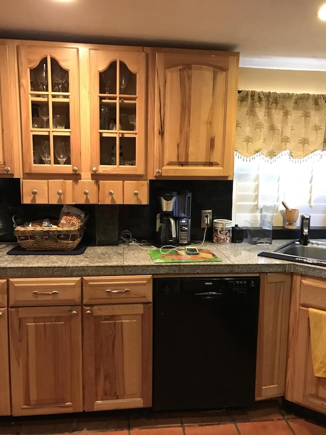 kitchen featuring sink, dark tile patterned flooring, and dishwasher