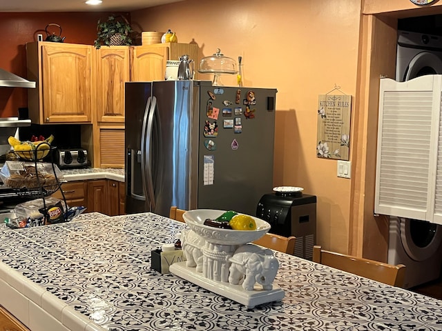 kitchen featuring ventilation hood and stainless steel refrigerator with ice dispenser