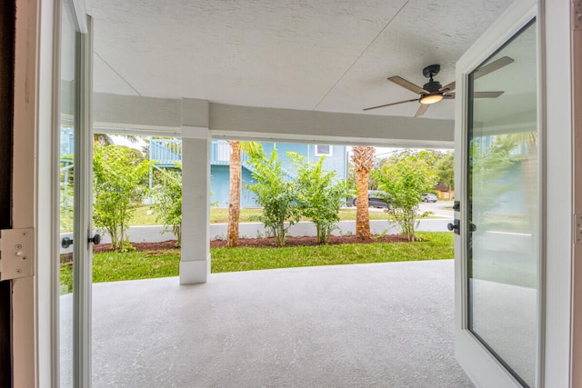 exterior space featuring ceiling fan and a textured ceiling