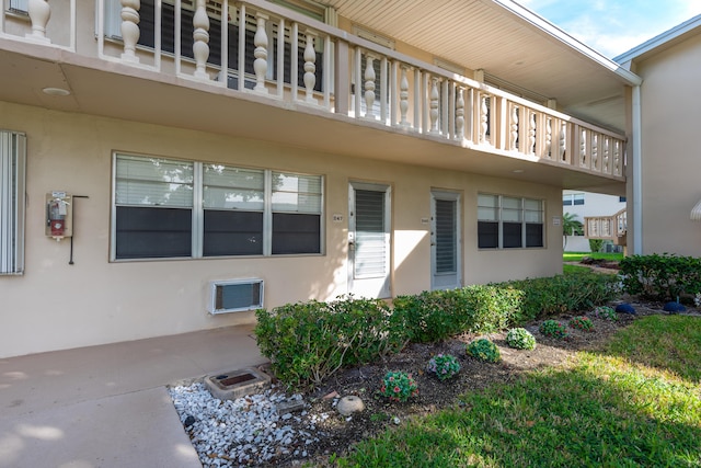 view of exterior entry with a balcony