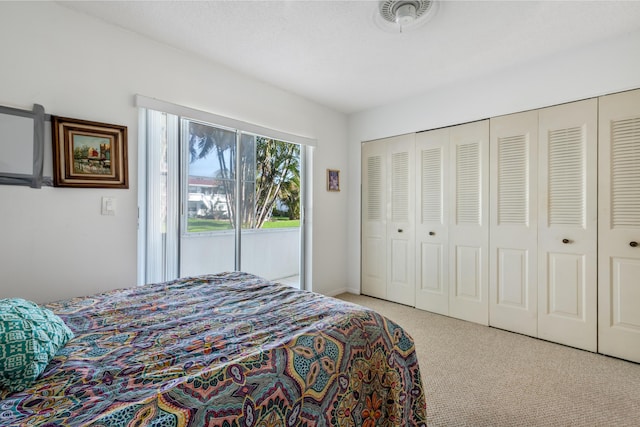 bedroom featuring a closet, carpet flooring, visible vents, and access to outside