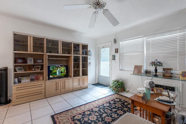 living area with light tile patterned floors, a textured ceiling, and a ceiling fan