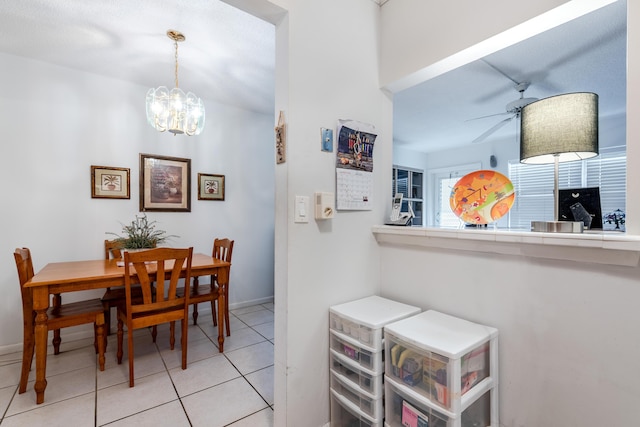 dining area featuring baseboards, light tile patterned flooring, and ceiling fan with notable chandelier