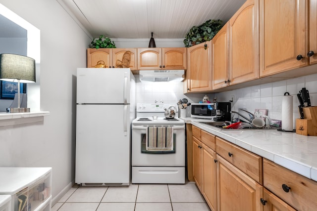 kitchen featuring backsplash, white appliances, light tile patterned floors, and under cabinet range hood