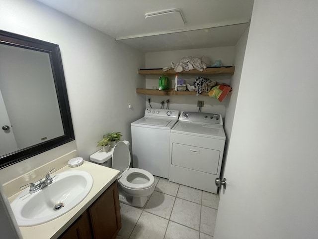 half bath with toilet, tile patterned flooring, washer and dryer, and vanity