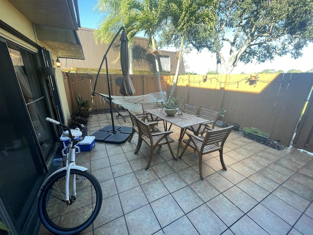 view of patio with outdoor dining space and fence