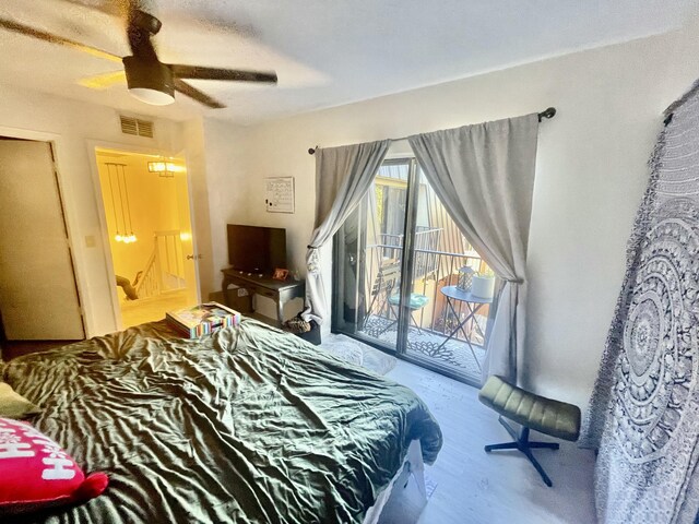 bedroom featuring access to exterior, a ceiling fan, visible vents, and wood finished floors