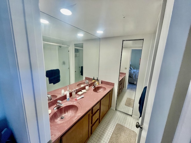 ensuite bathroom featuring a stall shower, a sink, ensuite bath, and tile patterned floors