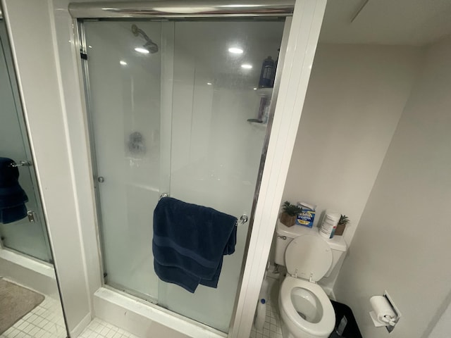 full bath with a stall shower, tile patterned flooring, and toilet