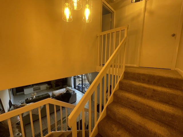 stairs featuring an inviting chandelier