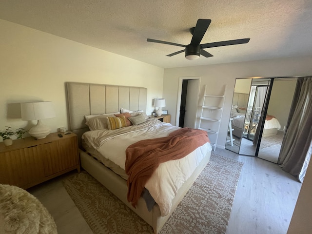 bedroom with a textured ceiling, access to outside, light wood-type flooring, and a ceiling fan