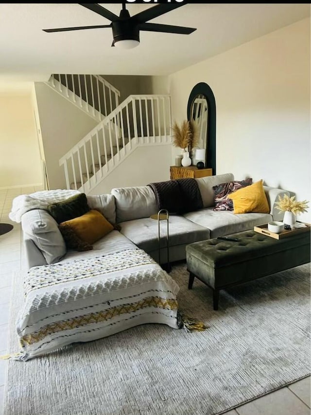 living room with stairway and a ceiling fan