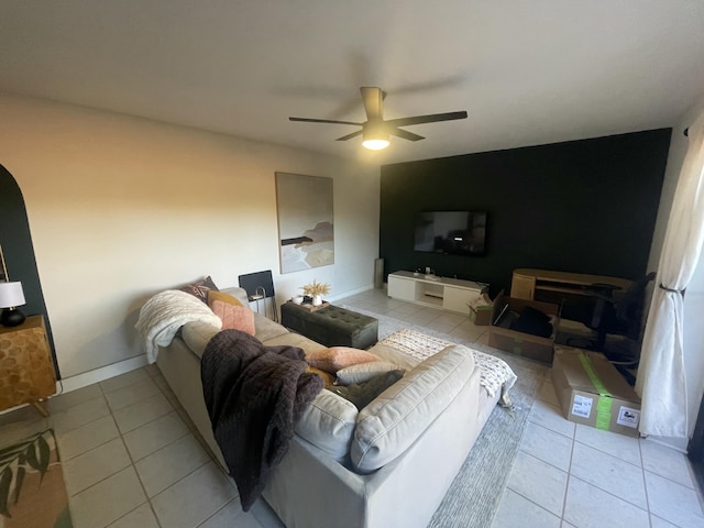 living room with ceiling fan, baseboards, and light tile patterned floors