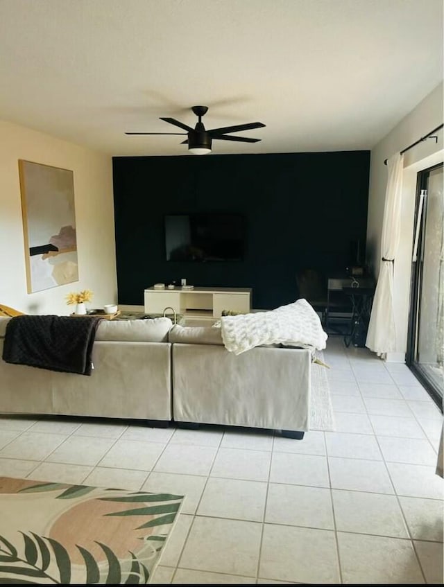 living area with ceiling fan and light tile patterned flooring