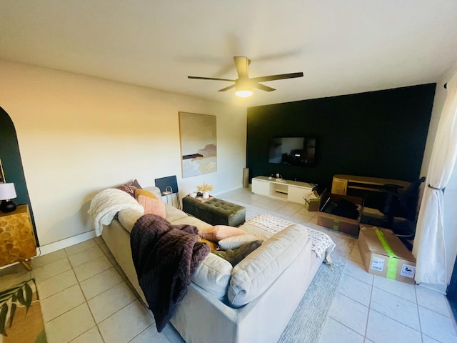 living room with a ceiling fan, light tile patterned flooring, and baseboards