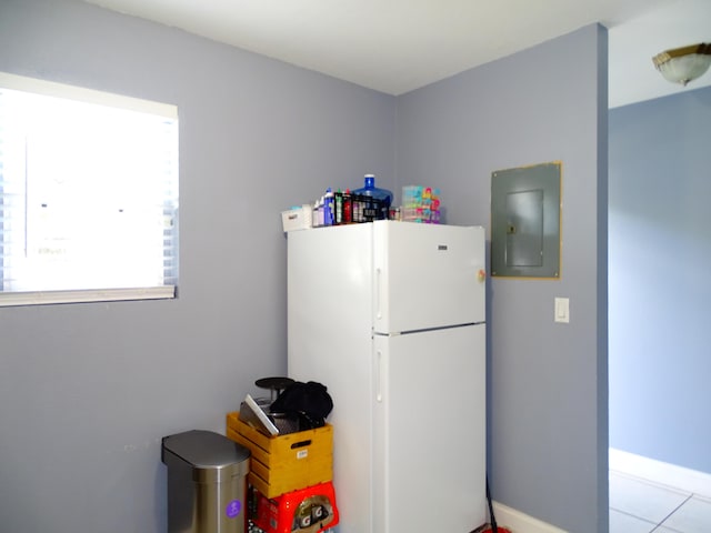 kitchen featuring electric panel, white fridge, and light tile patterned floors