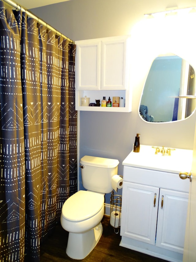 bathroom featuring wood-type flooring, vanity, toilet, and curtained shower