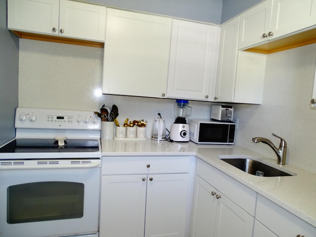 kitchen with white cabinets, white appliances, sink, and tasteful backsplash