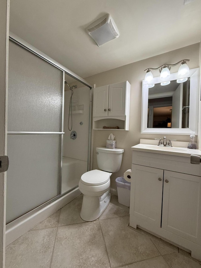 bathroom with tile patterned floors, vanity, toilet, and a shower with door