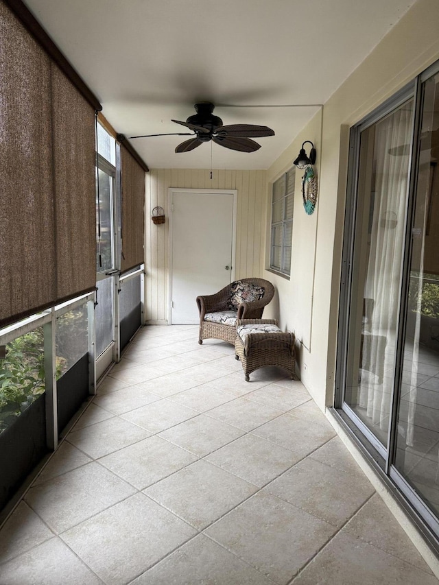 unfurnished sunroom with ceiling fan