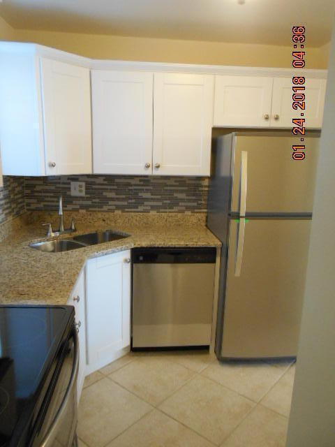 kitchen featuring white cabinets, sink, light tile patterned floors, and stainless steel appliances