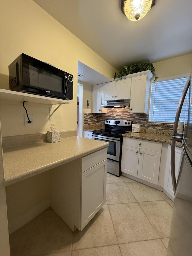 kitchen featuring light tile patterned flooring, white cabinetry, stone countertops, appliances with stainless steel finishes, and decorative backsplash