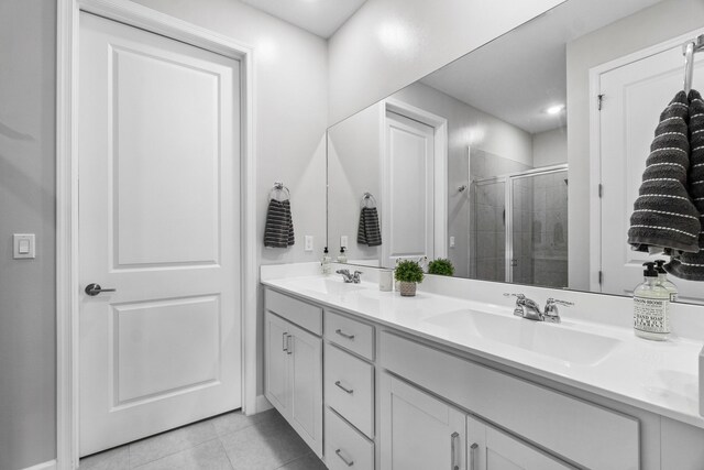 bathroom featuring tile patterned floors, vanity, and a shower with shower door