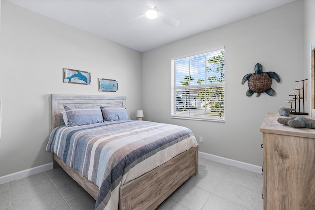 bedroom with light tile patterned floors, ceiling fan, and baseboards