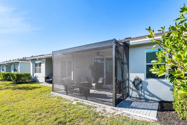 back of property with a sunroom and a yard