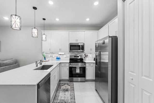 kitchen with backsplash, sink, appliances with stainless steel finishes, decorative light fixtures, and white cabinetry