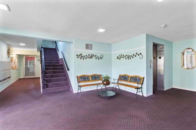 living area featuring elevator, dark colored carpet, and a textured ceiling