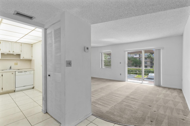 kitchen with sink, light tile patterned flooring, and white dishwasher