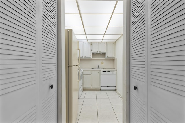 kitchen with sink, white appliances, and light tile patterned flooring