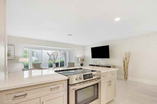 kitchen featuring light tile patterned floors and stainless steel electric stove