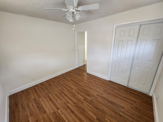 unfurnished bedroom with a textured ceiling, dark hardwood / wood-style flooring, a closet, and ceiling fan