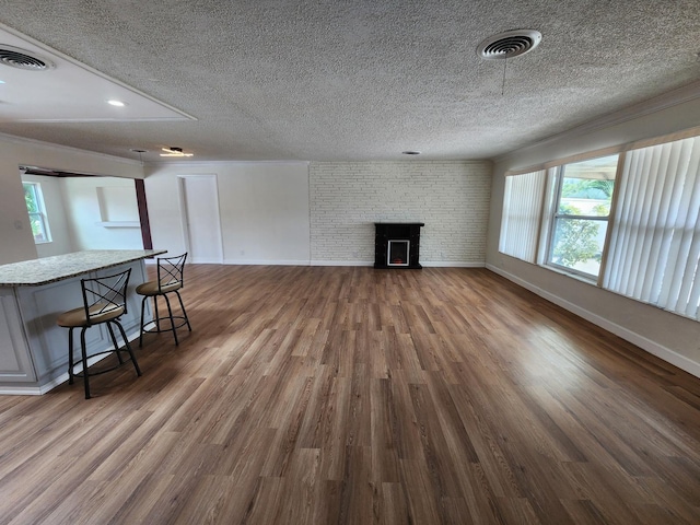 unfurnished living room featuring a fireplace, dark hardwood / wood-style flooring, and a textured ceiling