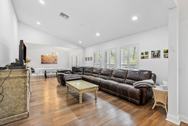 living room featuring vaulted ceiling and light hardwood / wood-style flooring