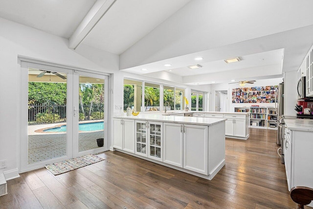 kitchen featuring kitchen peninsula, white cabinetry, plenty of natural light, and dark hardwood / wood-style flooring