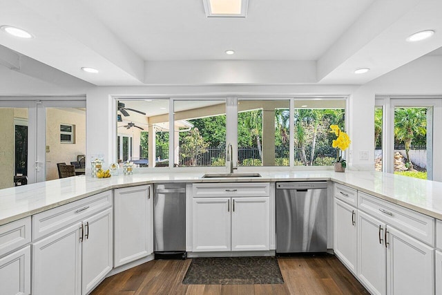 kitchen featuring light stone counters, stainless steel dishwasher, sink, dark hardwood / wood-style floors, and white cabinetry