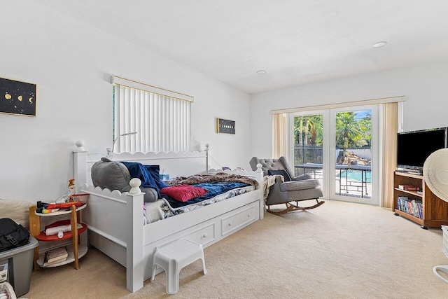 bedroom featuring access to exterior and light carpet