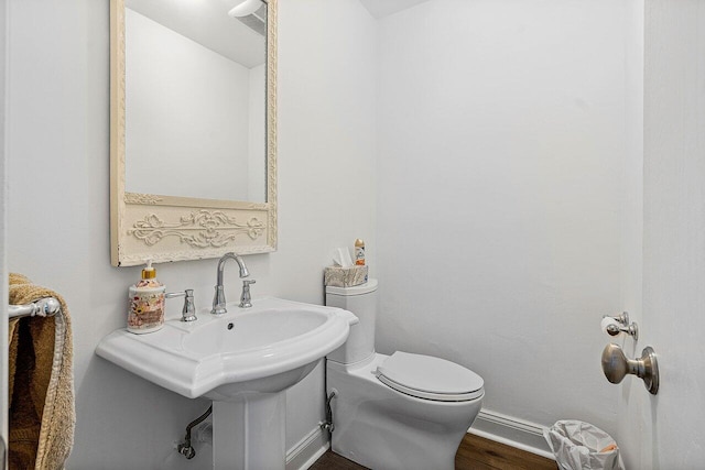 bathroom with hardwood / wood-style flooring, sink, and toilet