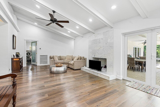 living room with a fireplace, hardwood / wood-style floors, lofted ceiling with beams, and ceiling fan